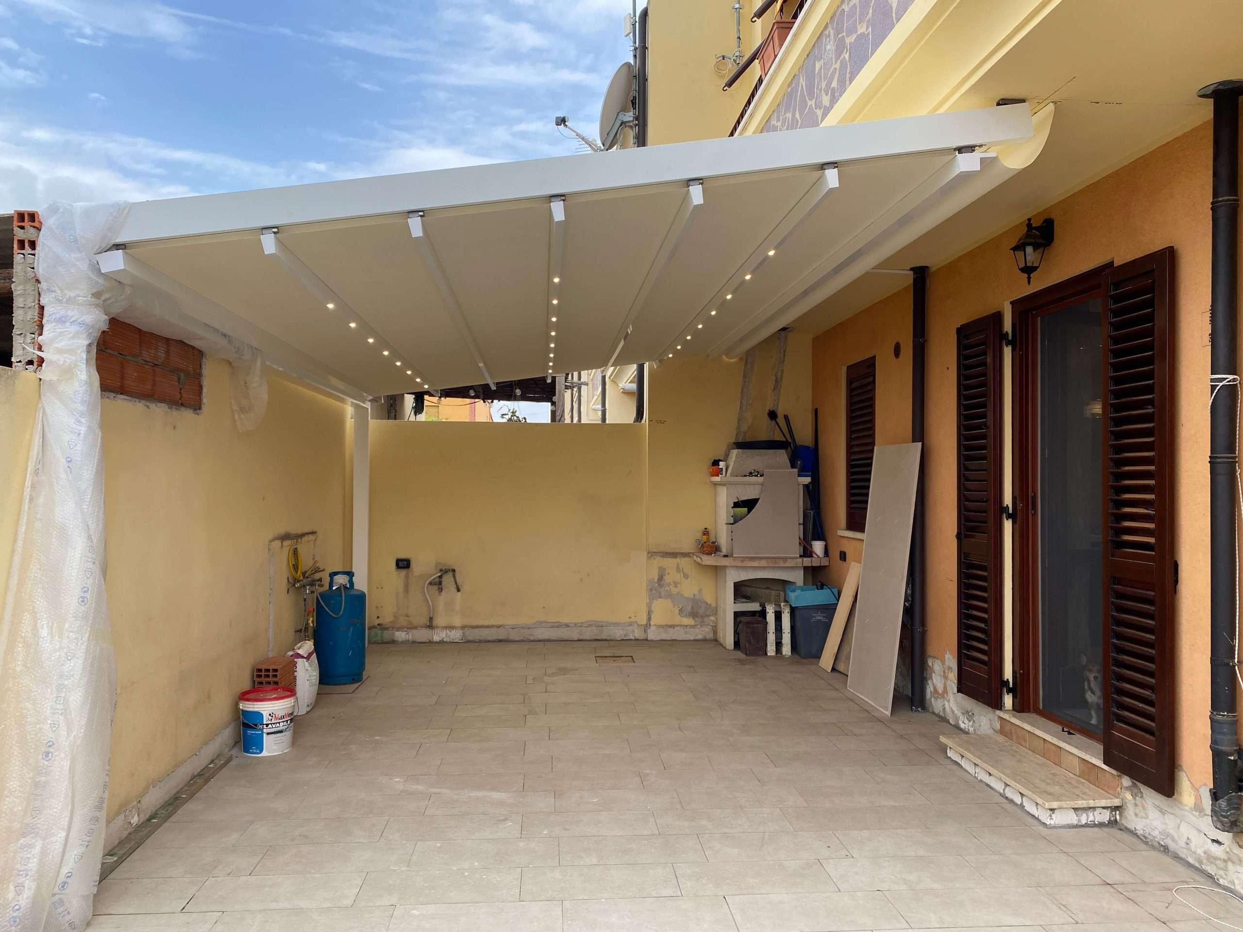 Area esterna di una casa a Decimoputzu in cui è stata installata una pergotenda ed è ancora in corso un'intervento edilizio progettato dall'ingegnere Valeria Siddi
